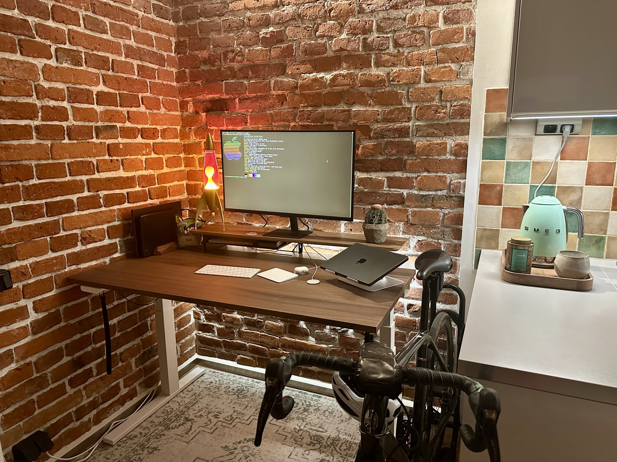 The new standing desk: monitor, Magic Keyboard, and Magic Trackpad up top, bike parked underneath