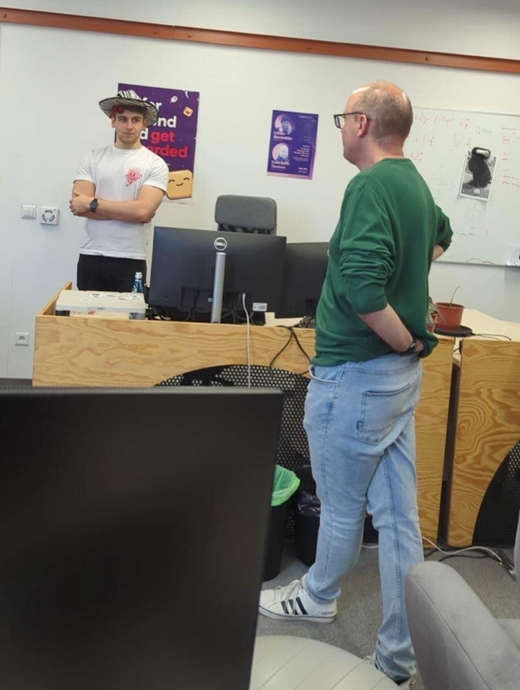 Me, wearing a hat, talking with Cezary (whose legs are apparently doing the twister)